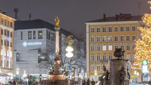 Fish Fountain, Fischbrunnen in front of the New New Town Hall at Marienplatz night timelapse, the historic center square illuminated during rain evening in Munich, Germany
