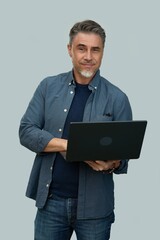 Casual mid adult man standing holding laptop computer. Portrait of happy middle aged male in 50s with gray hair, smiling. Isolated on white background.