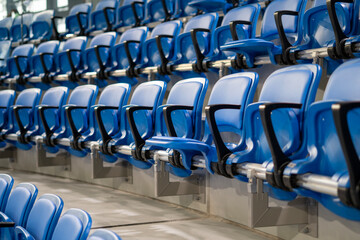 A long row of modern blue chairs with folding seats in a hall