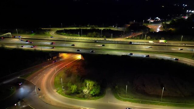 High Angle Night Footage of Illuminated British Motorways and Traffic on M1 Junction 9 at Just After Sunset. Redbourn, England United Kingdom. April 7th, 2024 