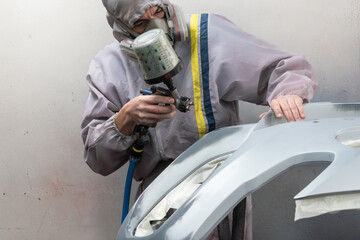 Auto Body Technician Spraying Paint on Bumper