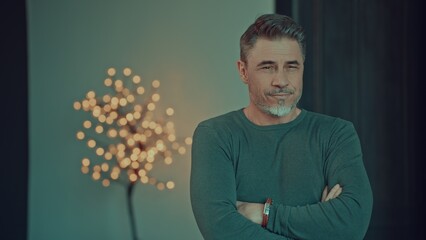 Portrait of happy confident mid adult man at home, smiling. Gray hair, bearded middle aged male looking away indoors.
