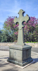 Croix en marbre vert avec un arrière plan fleuri