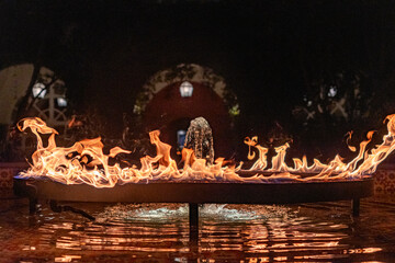 Night photograph of A ring of fire over a fountain of water in the center of a plaza in Mexico...