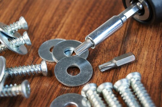 Working environment. Screws for concrete and metal washers on a wooden table. 