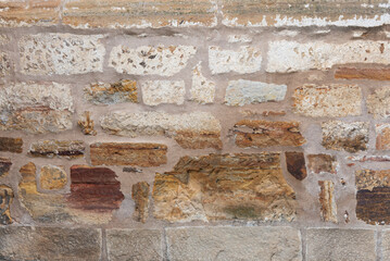 old brick wall with different colors and shapes of the stones