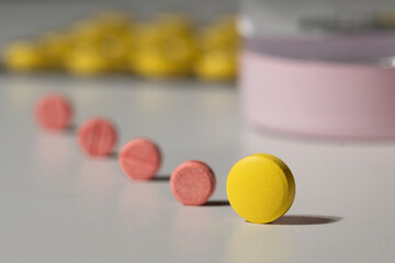 Colorful Pills and a Glass of Water on a White Background