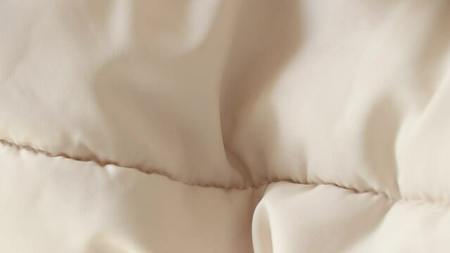 White puffy winter jacket as a background close-up, white background