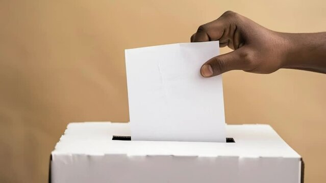 African American male hand putting vote in ballot box against ivory background. Ballot box with man casting vote on white blank voting slip