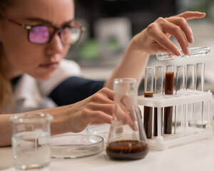 Caucasian woman in a medical gown doing laboratory experiments. 