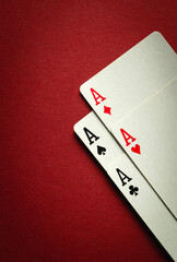 A winning combination of four aces in playing cards or four of a kind or quads. Concept of luck in the game of poker on a red table. Place for advertising
