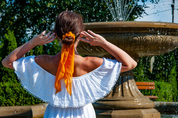 Woman in white romantic dress at fountain water. Summer vacation. Travel destination. Summer...