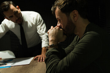 Detective interrogating a nervous man in a dimly lit interrogation room - obrazy, fototapety, plakaty