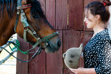 Woman with horse in stable at countryside ranch. Girl horse rider in summer outdoor. Equestrian and...