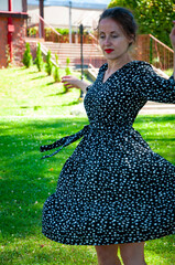 Summertime fashion style. Woman in summer dress dancing on the green grass. Romantic girl dance on...