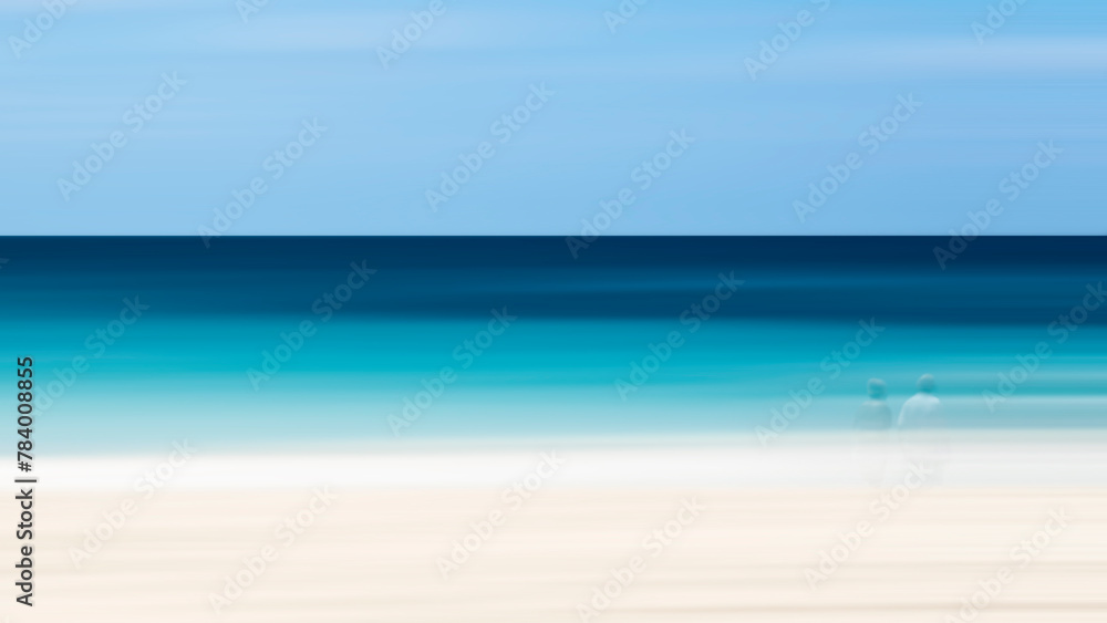 Aufkleber a blurry image of a beach with a man and woman standing on the sand. scene is calm and serene, with 