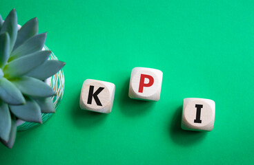 KPI- Key Performance Indicator. Wooden cubes with word KPI. Beautiful green background with...