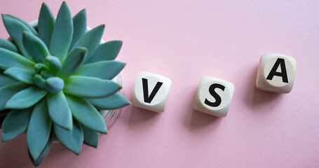 VSA - Volume Spread Analysis symbol. Wooden cubes with word VSA. Beautiful pink background with...