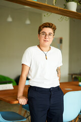 Transgender professional stands confidently in office, showcasing inclusivity in modern workplace....