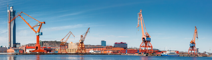 Gothenburg port loading cranes panorama against a backdrop of skyscrapers and blue skies, concept of maritime and industry. Gothenburg, Sweden - obrazy, fototapety, plakaty