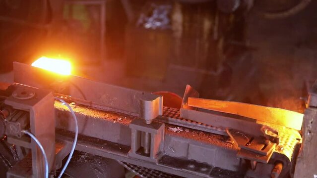 induction billet heating process system. forge shops quickly heating up metal block.  billet making process in an induction heating furnace at a forging factory. red yellow hot molten iron steel blank