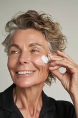 mature skin care, a woman with radiant skin applies an anti-aging cream with a confident smile