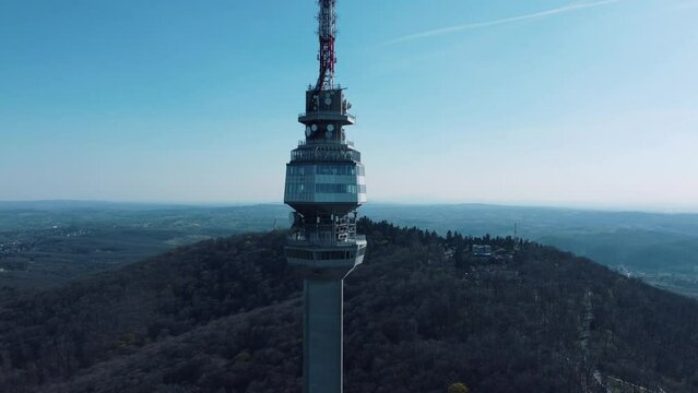 Majestic tall radio tower in Avala, Belgrade, Serbia under the clear blue sky pointing in the clouds