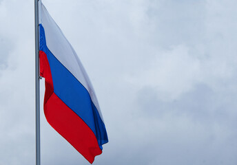 The Russian flag flutters in the wind against the blue sky, Background.