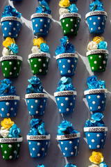 Small pots with flowers sold as souvenirs with the engraved name of the city of Cordoba, Andalusia, Spain.