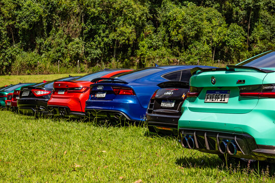 Colorful lineup of German performance cars parked on grass at an outdoor event