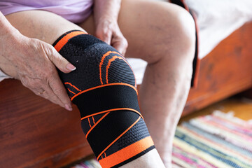 Old hands on knees, legs in knee pads, elderly man with sore arms and legs, arthritis and joint pain