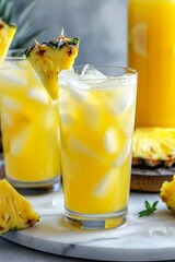 An overflowing glass of pineapple and ginger lemonade in a refreshing and stimulating vision. Golden colored lemonade sparkles under the light.