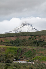 View of the Peñón de la Mata (1668 m.), beautiful mountain of Sierra Arana (Andalusia, Spain) after an intense snowfall in spring