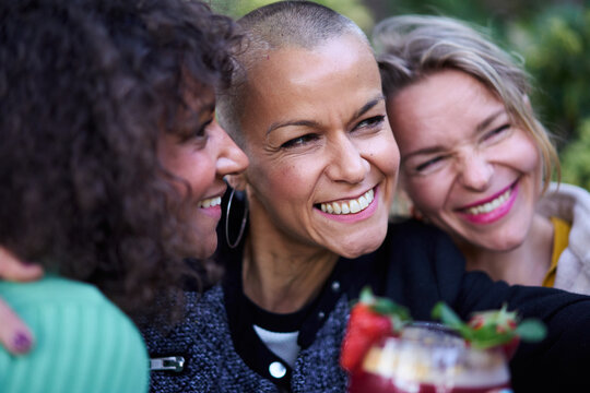 Close up of three beautiful smiling middle-aged multicultural women taking selfie outdoor. Group of nice cheerful mature friends enjoying meeting having fun. Adult friendship positive relationships 