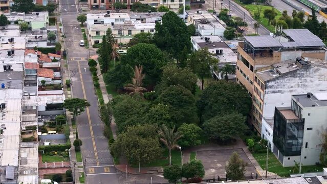 Panorámica aérea de un parque con árboles, rodeado por casas de vivienda y algunos edificios, en la ciudad de Bogotá - Colombia, donde también se ve la autopista norte con automóviles pasando