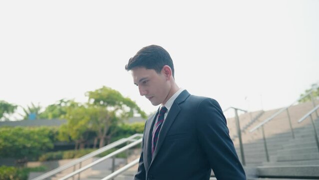 Shot of white business man in stylish suit walking down urban walking stairs with business case in hands. Active city lifestyle, work under probation, start up business, stating new job at new company