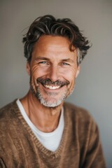 Cheerful mature man with a charming smile and grey hair in a portrait - obrazy, fototapety, plakaty