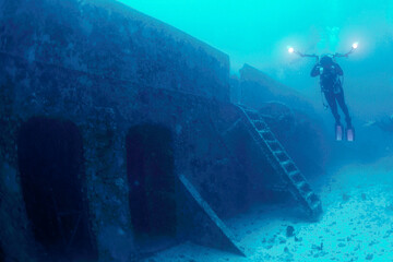 An underwater photographer exploring the Spiegel Grove shipwreck off Key Largo, Florida - obrazy, fototapety, plakaty