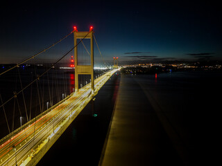 Fototapeta na wymiar Nighttime aerial view of illuminated suspension bridge
