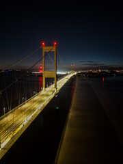 Nocturnal view of illuminated suspension bridge over water