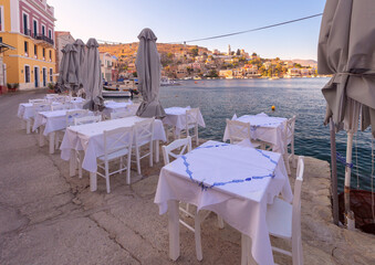 Street cafe above the sea on the embankment of the village Symi. - 784140856
