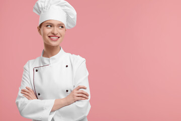 Happy woman chef in uniform on pink background, space for text