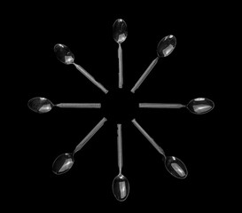 Food spoons mounted on top of each other in an artistic and elegant way in black and white.