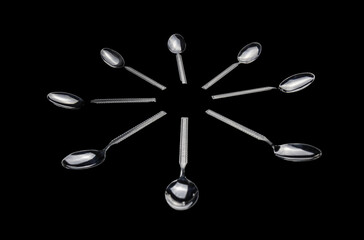 Food spoons mounted on top of each other in an artistic and elegant way in black and white.
