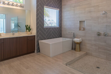 Luxuriant spa bathroom with tiled floor, walls, shower and rain shower head with copy space