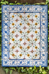 Obraz premium Traditional Blue and White Portuguese azulejos Tiles in a Flower Vase Design Mounted on a Garden Wall 