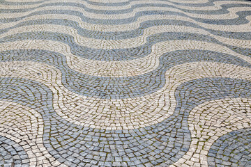 Undulating Waves of Black and White Stone Mosaic Sidewalk in Lisbon, Portugal  - 784156008
