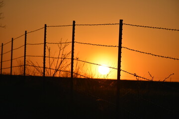 Orange Sunset Over a Barbed Wire Fence