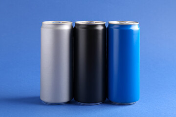 Energy drinks in colorful cans on blue background