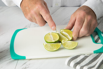 a bartender slicing limes into wedges for cocktails